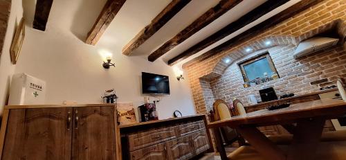 a kitchen with wooden cabinets and a brick wall at Conac Bistreanu in Eforie Sud