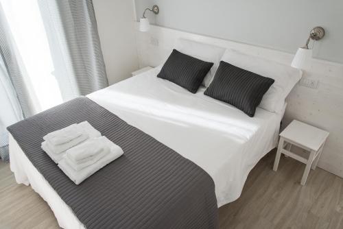 a large white bed with two folded towels on it at B&B Bucci 54 in Morciano di Romagna