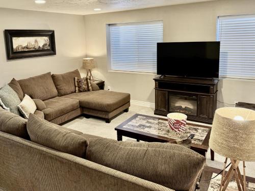 a living room with a couch and a flat screen tv at Charming Provo Home close to BYU and Utah Lake in Provo