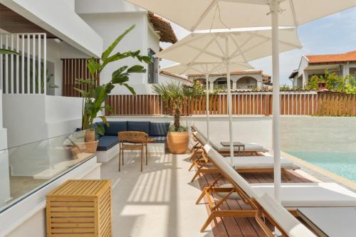 an outdoor patio with a table and chairs and an umbrella at Palm Boutique Suites in Pefkohori