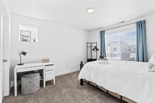 a bedroom with a bed and a desk and a window at Modern 3BR Townhome in Lehi UT in Lehi