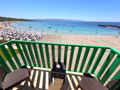 a view of a beach with chairs and umbrellas at Hotel Dei Pini in Alghero