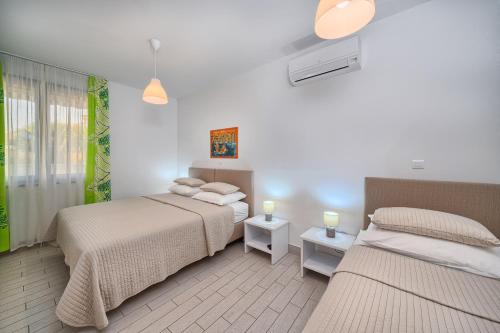 a bedroom with two beds and two lights on the wall at Apartments Kamelija in Split
