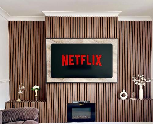 a netflix sign on a wall in a living room at Luxury House in Glasgow in Mansewood