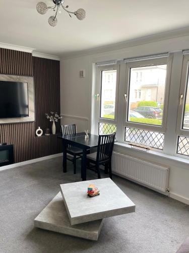 a living room with a table and chairs and windows at Luxury House in Glasgow in Mansewood