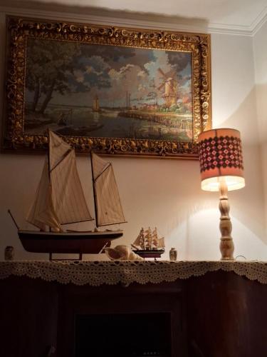 a painting above a fireplace with a toy boat on it at Retro Groove in Palaiochora