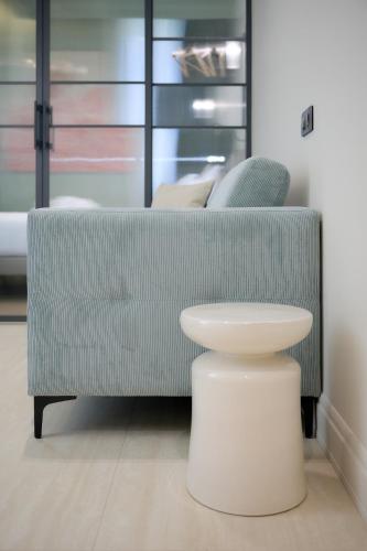 a living room with a couch and a stool at Aparthotel 9 ALBERTI Nice Centre in Nice