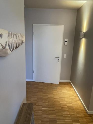 a hallway with a white door and a wooden floor at Port of Travemünde, Opening 2021 in Travemünde
