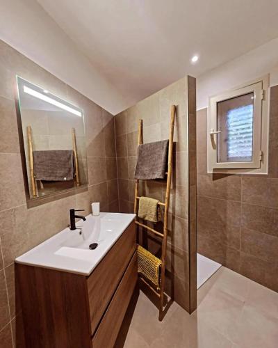 une salle de bain avec un lavabo et un miroir dans l'établissement Maison charmante à Propriano avec vue sur la montagne, à Propriano