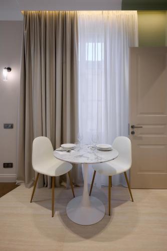a white table and two white chairs in a room at Aparthotel 9 ALBERTI Nice Centre in Nice