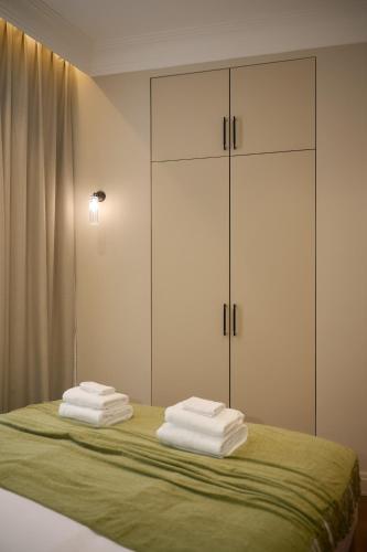 a bedroom with a bed with white cabinets and towels at Aparthotel 9 ALBERTI Nice Centre in Nice