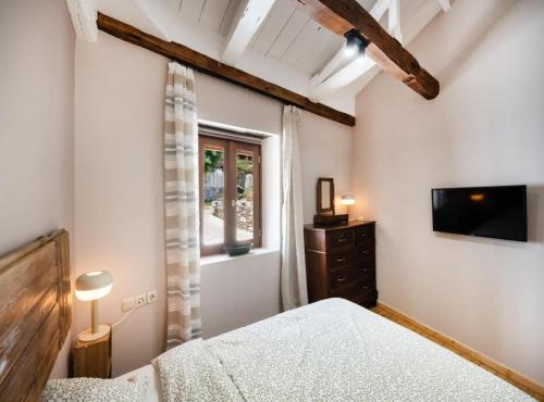 a bedroom with a bed and a tv and a window at Anyfantata in Sívros