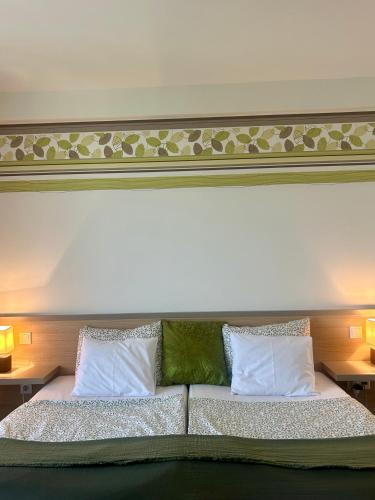 a bedroom with a large bed with two pillows at Kisfaludy Kásté in Dobronhegy