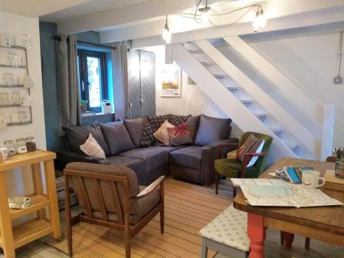 a living room with a couch and a staircase at Farmhand Cottage in Narberth