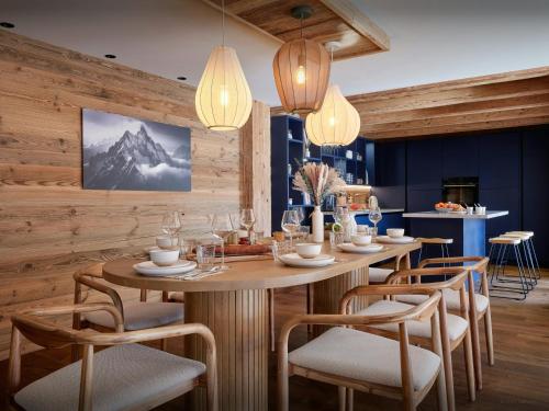 - une salle à manger avec des murs en bois, une table et des chaises dans l'établissement Le Repos du Bélier - OVO Network, à La Clusaz