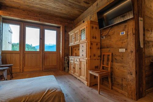 a bedroom with a bed and a large window at Casa Aquila, con sauna privata in Chiave