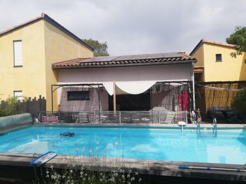 une maison avec une piscine devant une maison dans l'établissement Studio avec terrasse au calme, au Cannet-des-Maures