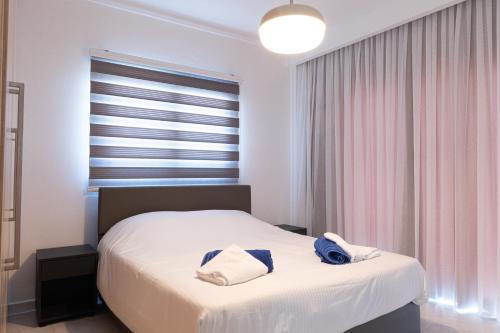 a bedroom with a bed with two towels on it at Protaras Plaza Hotel in Protaras