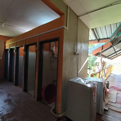 a room with a washing machine in a house at Kinabalu Poring Vacation Lodge in Kampung Poring