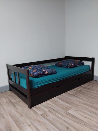 a wooden bed with two pillows on it at Grand appartement in LʼIsle-Jourdain