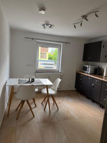 a kitchen with a table and chairs in a room at Schöne EG Wohnung in Kolbermoor