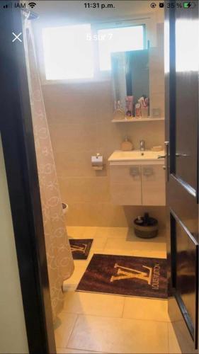 a small bathroom with a sink and a refrigerator at Salam Beach in Pont Blondin