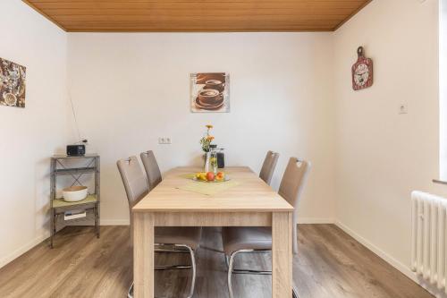 a dining room with a wooden table and chairs at Ferienwohnung Landblick in Homberg