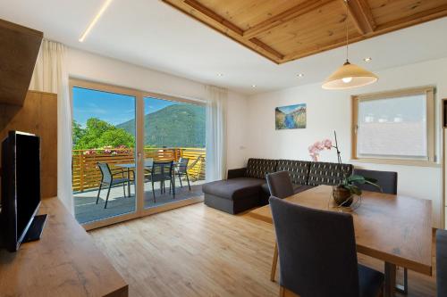 Una sala de estar con un sofá, una mesa y sillas. en Moarhof, en Rosa