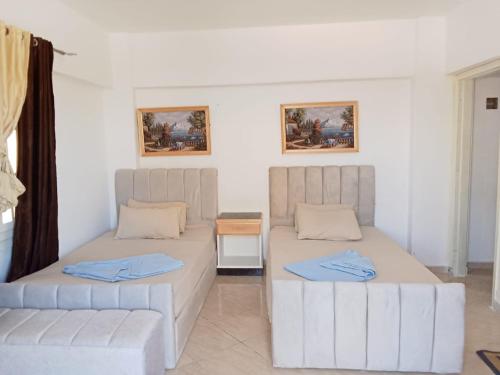 エル・アラメインにある1CH1 studio 2beds ground floor sea view 114 green beachのベッド2台とソファのある部屋