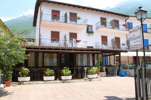 a large building with potted plants in front of it at Albergo Al Pescatore in Brenzone sul Garda