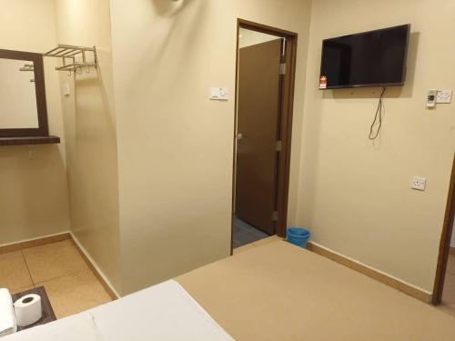 a room with a door and a television on the wall at The Pines Hotel in Tanah Rata