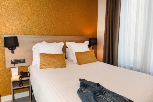 a hotel room with a bed with two pillows at Best Western Plus Le Havre Centre Gare in Le Havre