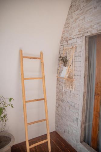 a wooden ladder leaning against a brick fireplace at Les Vagues - Hotel Villa & Beach Club - Gili Air in Gili Air