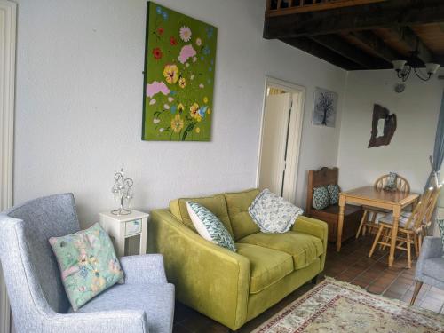 a living room with a yellow couch and two chairs at Cúig Cottage - Wild Atlantic Way, Galway in Inverin
