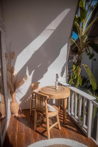 a wooden table and two chairs on a balcony at Les Vagues - Hotel Villa & Beach Club - Gili Air in Gili Air