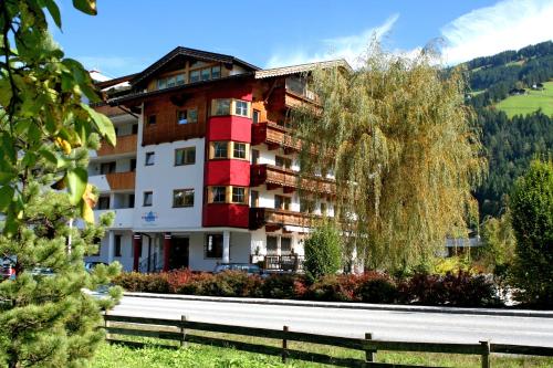 a large building with a tree in front of it at Alpenhotel Ramsauerhof in Ramsau im Zillertal