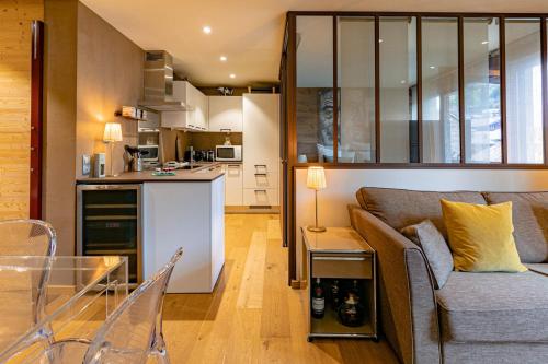 a living room and kitchen with a couch and a table at Arly in Megève
