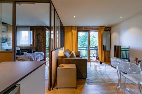 a living room with a bed and a couch in a room at Arly in Megève