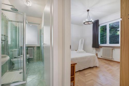 una camera da letto con un letto e un bagno con doccia di La Mèison de la Louye ad Aosta