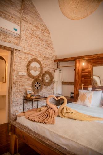 a bedroom with a bed with two towels on it at Les Vagues - Hotel Villa & Beach Club - Gili Air in Gili Air