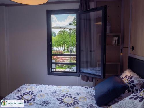 a bedroom with a bed and a window at Gite "Au Père Peinard" in Le Vibal