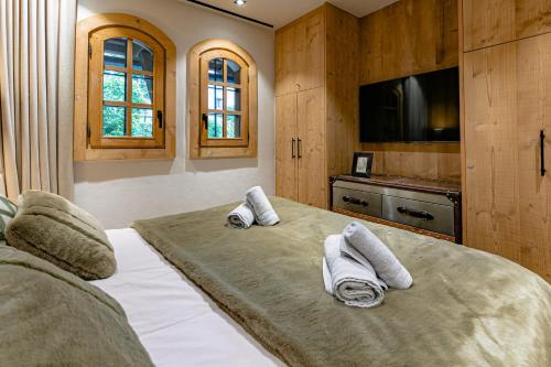 una camera da letto con un grande letto con asciugamani sopra di Escapade a Megève