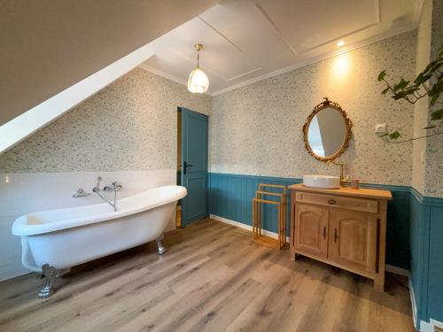 a bathroom with a tub and a sink and a mirror at English cottage - Logement atypique in Sarreguemines