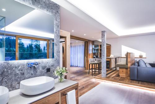 a bathroom with a sink and a living room at Hotel Klosterbräu in Seefeld in Tirol