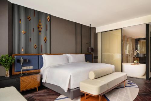 a bedroom with a large white bed and a chair at InterContinental Bangkok Sukhumvit by IHG in Bangkok