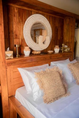 a bedroom with a bed with a wicker mirror at Les Vagues - Hotel Villa & Beach Club - Gili Air in Gili Air