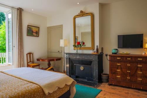 a bedroom with a bed and a mirror and a fireplace at Clos Ceres in Viré