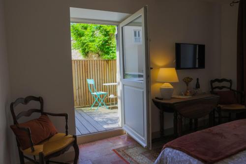 a bedroom with a door open to a patio at Clos Ceres in Viré