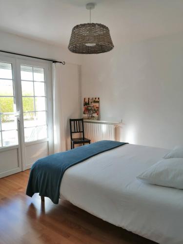 une chambre avec un grand lit et une chaise dans l'établissement Gite Papillon, à Vaux-sur-Mer