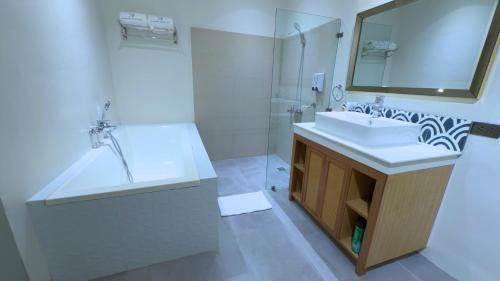 a white bathroom with a sink and a mirror at Whiterock Beach Hotel and Waterpark in Subic